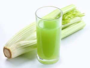 juice from the stalks of celery plants on white background.