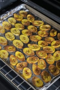 Cooked plantain chips on baking sheet