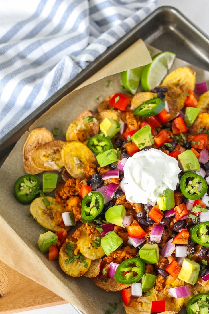 Loaded plantain nachos on a baking sheet.