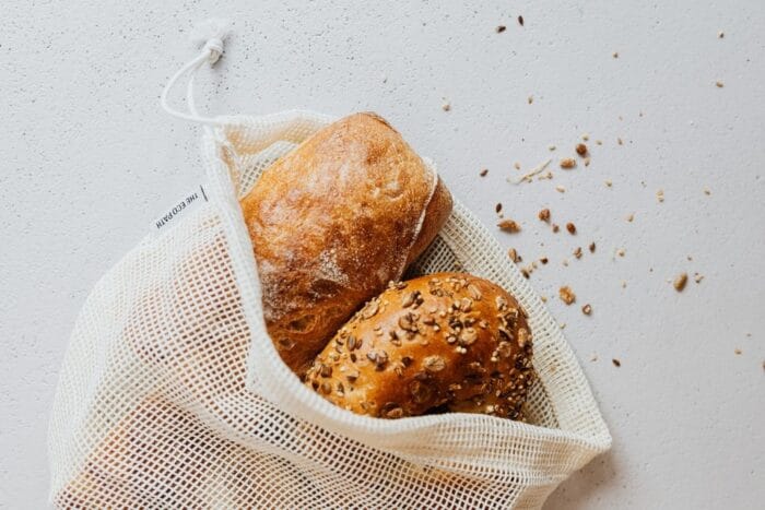 Fresh bread loaves in a reusable produce bag. 