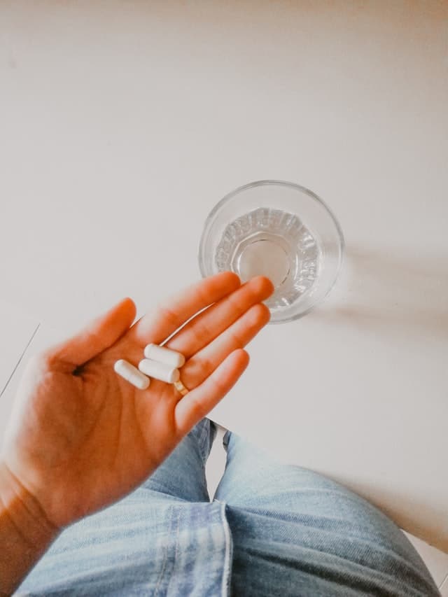 woman holding supplements in her hand