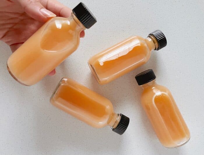 Homemade ginger shots on a white quartz countertop. 