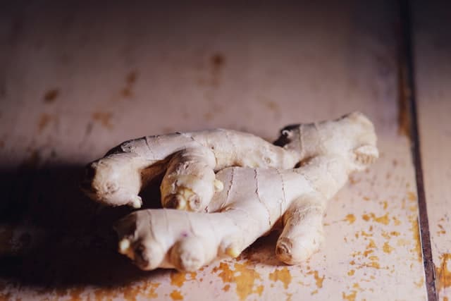 a large piece of fresh ginger resting on a scuffed tabletop 